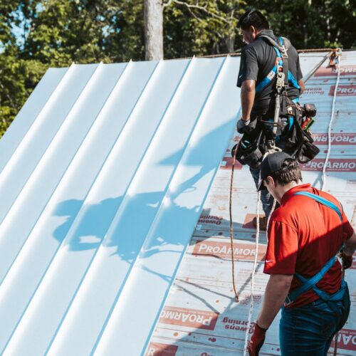 A group of men working on the roof of a building.